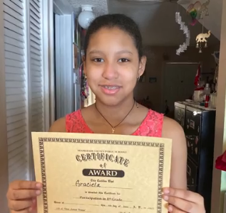 Graciela holding up an award certificate. 