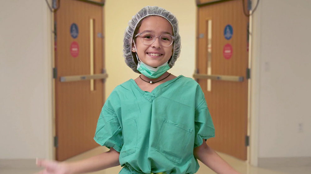 recovered patient, maja, in surgical scrubs as she tours the hospital