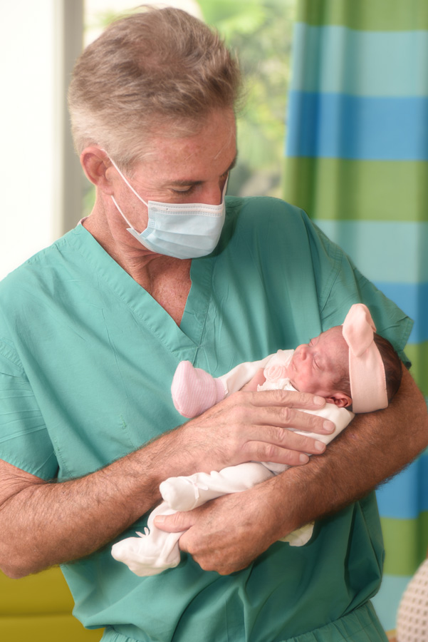 Cardiac surgeon Dr. Burke holding baby Alia