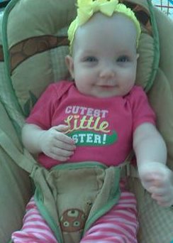 Gianna in a car seat wearing a shirt that says Cutest little sister.