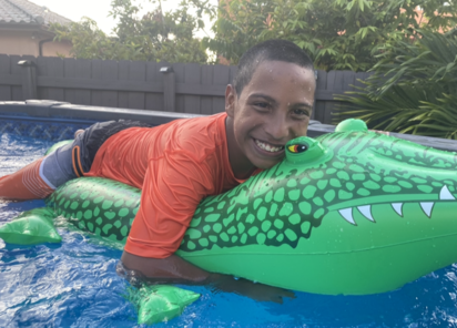 Jacob in a pool on an alligator floaty