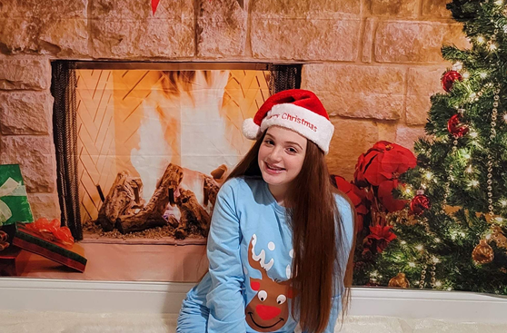 Melany smiling in Christmas attire