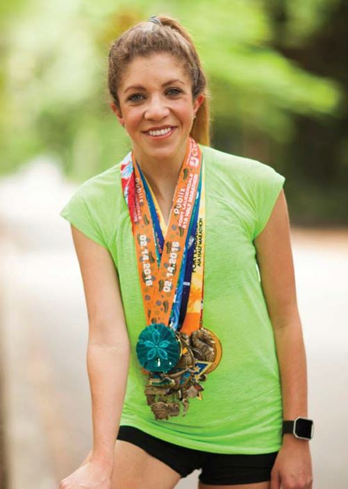 Sarah wearing several marathon medals. 